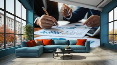 Business partners discussing financial reports at meeting. Two business partners review financial documents, discussing performance charts and graphs during an office meeting. Wall mural