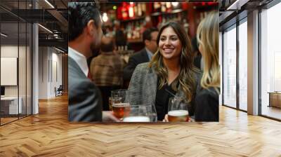 Friendly Networking Event at a Cosy Bar. Smiling young woman engaging in a conversation at a vibrant networking event in a cozy bar with beer glasses. Wall mural