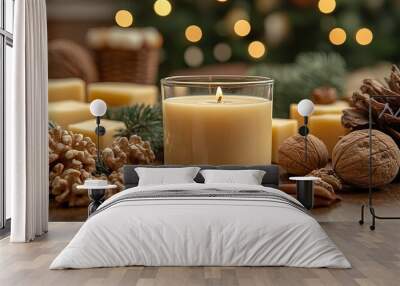 A flickering candle illuminates a rustic winter scene with pine boughs, walnuts, and natural elements. Wall mural