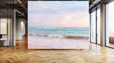 Sandy beach pastel background. Blue cloudy sky and soft ocean wave in warm sunset light Wall mural