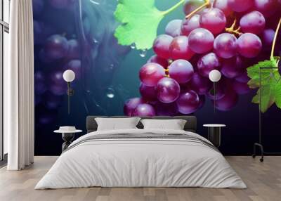  a bunch of grapes hanging from a vine with a green leaf on the end of one of the grape clusters. Wall mural