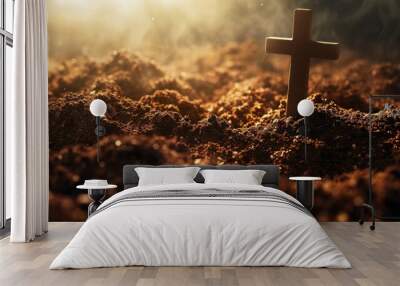  a close up of a cross in a pile of dirt with sunlight coming through the clouds in the back ground. Wall mural