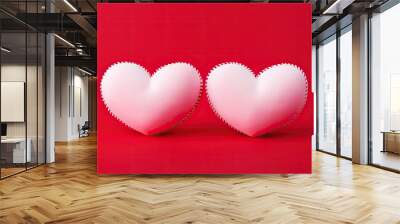  two heart shaped pillows sitting on top of a red table next to each other on top of a red surface. Wall mural