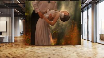 A young beautifu couple dance in a forest Wall mural