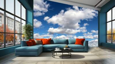 Blue sky covered with white cumulus and cirrus clouds. Spring cloudscape, beautiful weather background Wall mural