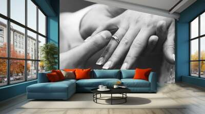 Groom put ring on bride's hand on wedding ceremony, tender black and white photo Wall mural