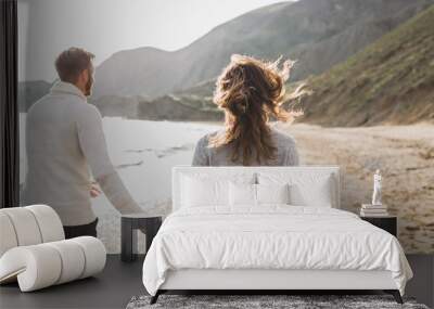 Man and woman in love enjoying together near sea, running by the beach, laughing, kissing and hugging Wall mural