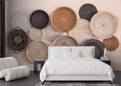 Wall decorated with different wicker handmade trays and baskets. Eco style and concept, Moroccan culture. Wall mural