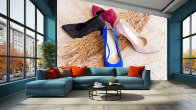 Four women's shoes red, blue, beige, black on a background of stalks of wheat. Wood background. Wall mural