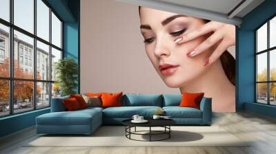 Beauty brunette woman with perfect makeup. Red lips and nails. Perfect eyebrows. Skin care foundation. Beauty girls face isolated on beige background. Fashion photo Wall mural