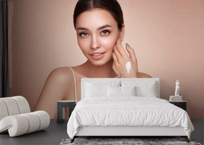 Beauty woman applying cream on her hands. Young woman with clean fresh skin Wall mural