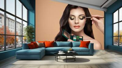 Makeup artist applies eye shadow. Beautiful woman face. Perfect makeup. Make-up detail. Beauty girl with perfect skin. Nails and manicure. Eye shadow palette Wall mural