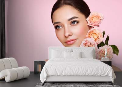 Portrait beautiful young woman with clean fresh skin. Model with healthy skin, close up portrait. Cosmetology, beauty and spa. Girl with a rose flower Wall mural