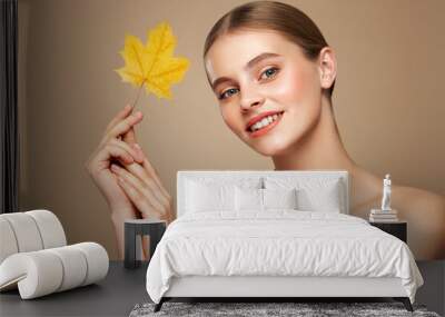 Portrait of beautiful young woman with autumn leafs. Healthy clean fresh skin natural make up beauty eyes Wall mural