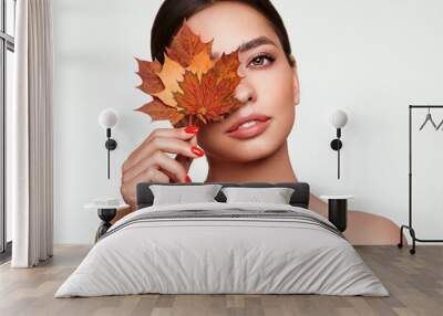 Portrait of beautiful young woman with autumn maple leafs. Healthy clean fresh skin natural make up beauty eyes and red nails Wall mural