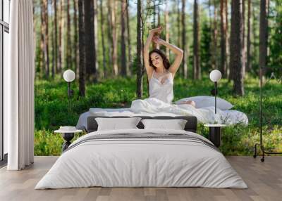 Woman sleeps on a mattress in the summer forest. Girl wakes up in a summer forest Wall mural