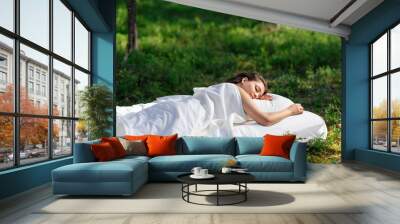 Woman sleeps on a mattress in the summer forest. The girl is resting in nature Wall mural