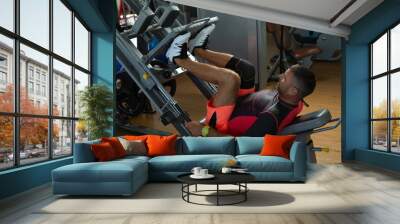 Man performing leg press exercise in the gym Wall mural