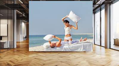 Newlywed couple fighting with pillows Wall mural