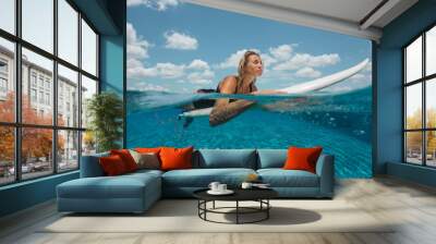 Positive girl swimming with surf and relax at poolside Wall mural