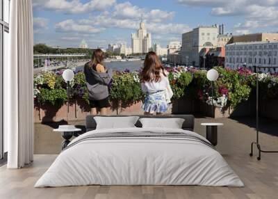 Two girls standing on city bridge om Moscow buildings background, travel in Russia Wall mural