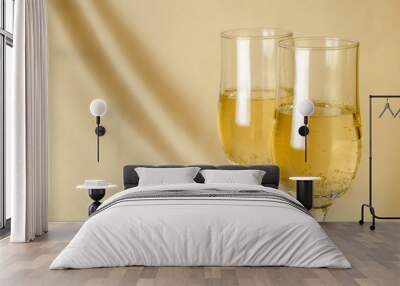 two glasses of champagne on a background of a fabric of golden color Wall mural