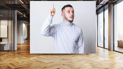 Inspired funny face young man with bristle pointing up and having an idea over gray background copy space Wall mural