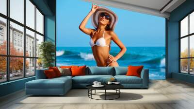 Portrait of sexy beautiful tanned woman posing in colorful swimwear bikini at the sea coast. Exotic country travel and rest concept. Slim figure and sexy body. Wall mural