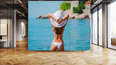 Sexy beautiful woman at the Mediterranean sea coast with ancient Wall mural