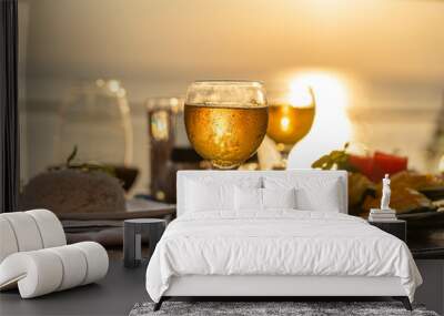 Two wine glasses on wooden table near sea on the tropical beach during sunset Wall mural