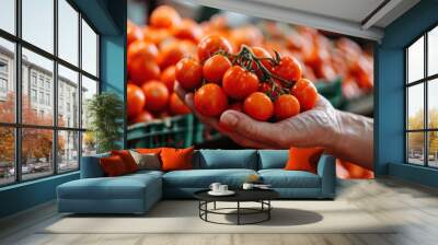 a hand is holding a fruit and vegetable stand full of red tomatoes Wall mural