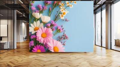 Colorful floral arrangement featuring daisies and wildflowers on a blue background Wall mural