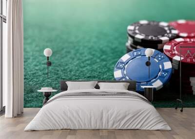 Colorful poker chips stacked on a green felt table in a casino setting during a game night Wall mural