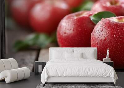 Fresh red apples arranged on a rustic wooden table with green leaves Wall mural