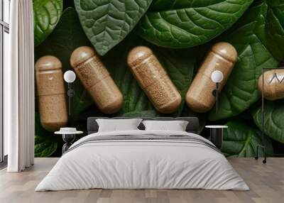 Herbal supplement capsules arranged on a bed of lush green leaves Wall mural