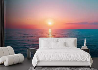 Sunset on the horizon, with the sun casting a warm glow over the sky and the sea Wall mural