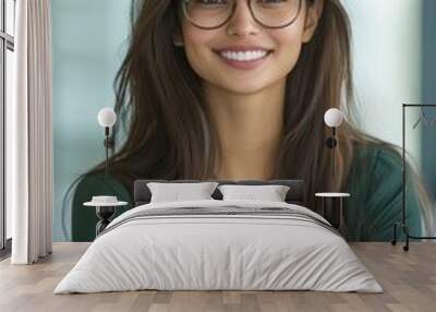 Young woman with long hair and glasses smiling confidently indoors in a bright and modern space Wall mural