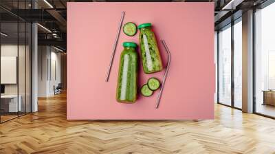 Cucumber vegan smoothie in two glass bottle, nutrient hydrating green juice, detox food, weight loss concept, pink background, top view ,metal straw,zero waste Wall mural