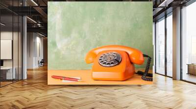 Vintage orange phone, sheet of paper and pen Wall mural