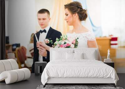 Bride and groom holding candles in church Wall mural