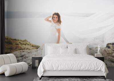 Romantic beautiful bride in white dress posing on the background sea Wall mural