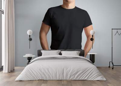 Front mockup black T-shirt on a young  guy isolated on a gray background. Wall mural