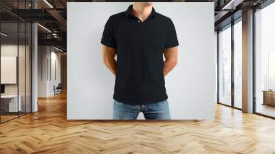 Mockup  black polo shirt on a strong guy. Isolated on a gray background. Wall mural