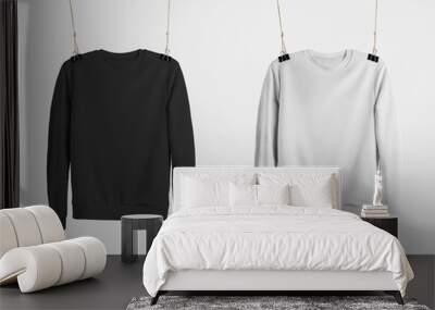 Mockup of black and white sweatshirts hanging on the ropes, empty pullovers for presentation of design, advertising in the online store. Wall mural