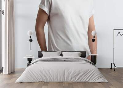 Stylish young guy in a blank t-shirt and black pants on a white clean background in the studio. Wall mural