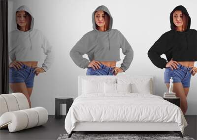 Template female hoodie on a pretty girl with hands on her belt, posing in a hood on a background in the studio, crop top for design presentation. Wall mural