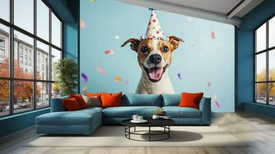 Joyful dog celebrates its birthday with a party hat, surrounded by falling confetti on a vibrant blue background. Perfect for greeting cards or event templates Wall mural