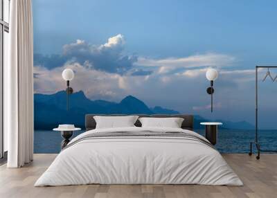 Sea before sunset with mountains and clouds in the background. Red and orange tones of the sky Wall mural