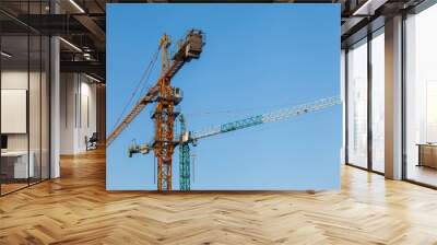 tower cranes on a background of blue sky Wall mural