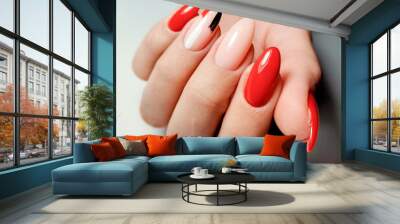 Bright red gel Polish with camouflage design and brushstrokes. A woman's hand with long almond-shaped nails and a multi-colored design. Wall mural